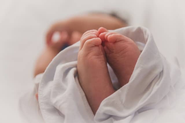 A close up image of a baby's feet with the rest of the body out of focus