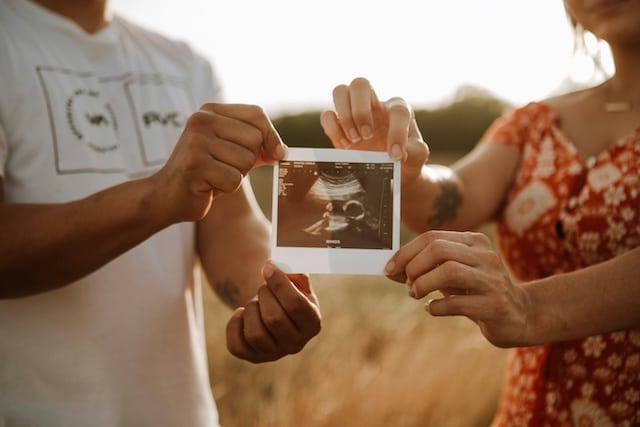 A woman and man holding an ultrasound image together